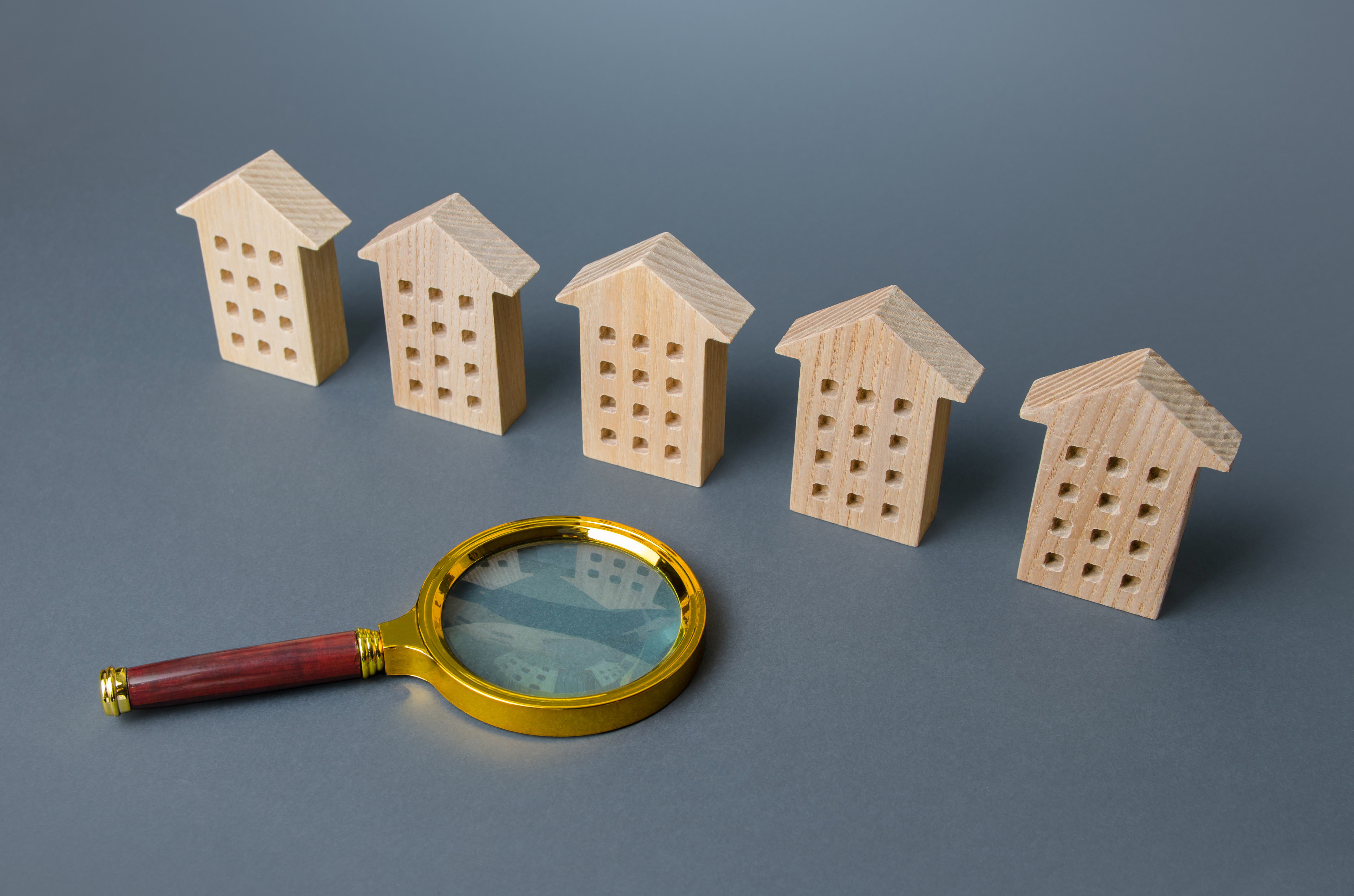magnifying glass and wooden flat buildings