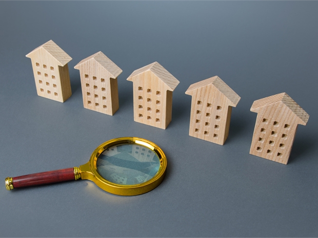 magnifying glass and wooden flat buildings