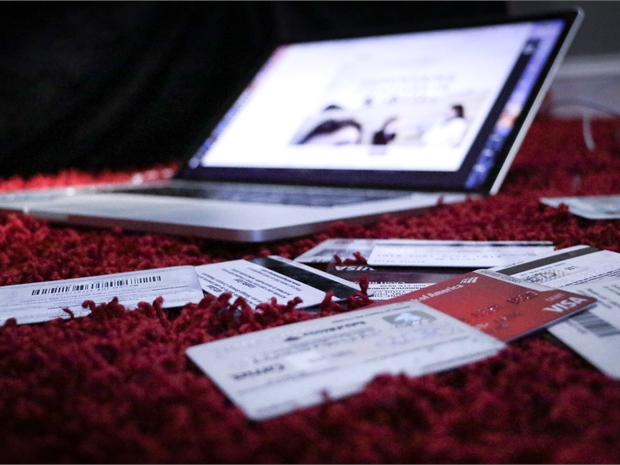 a laptop on a red carpet with credit cards surrounding it