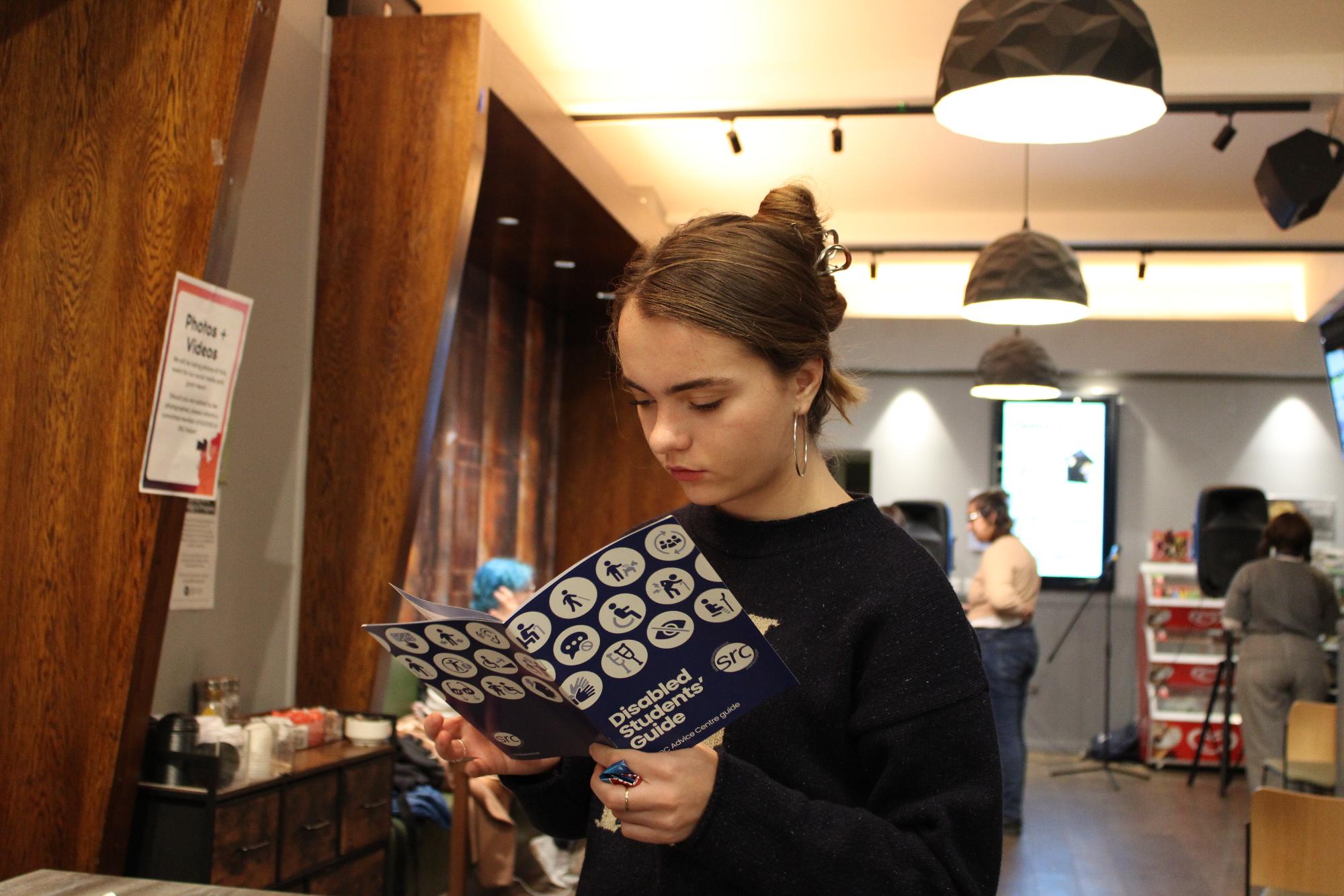 A student reviewing the SRC's Disabled Student Guide at the society's open mic night event.