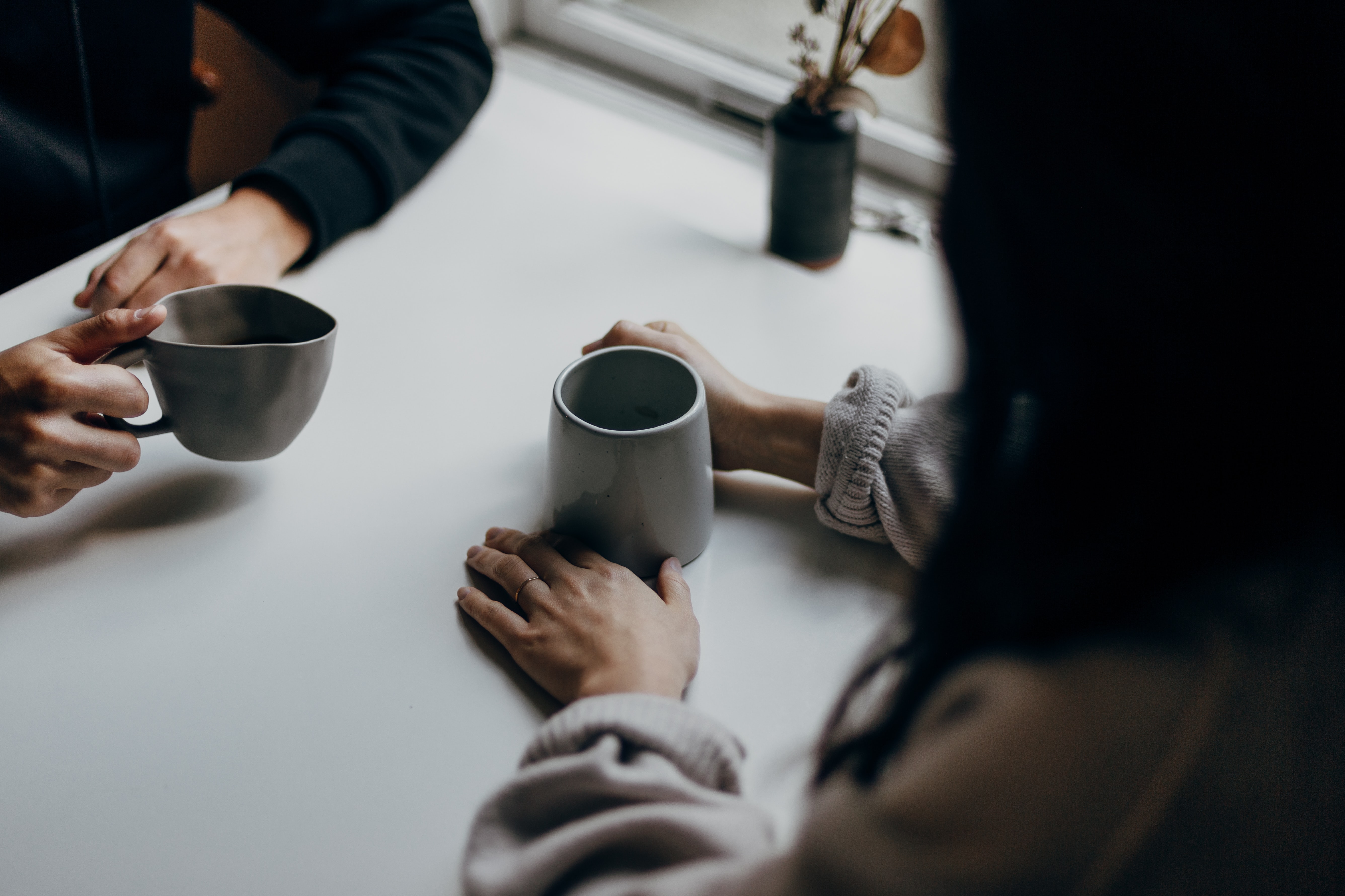 close up of people having hot drinks and talking