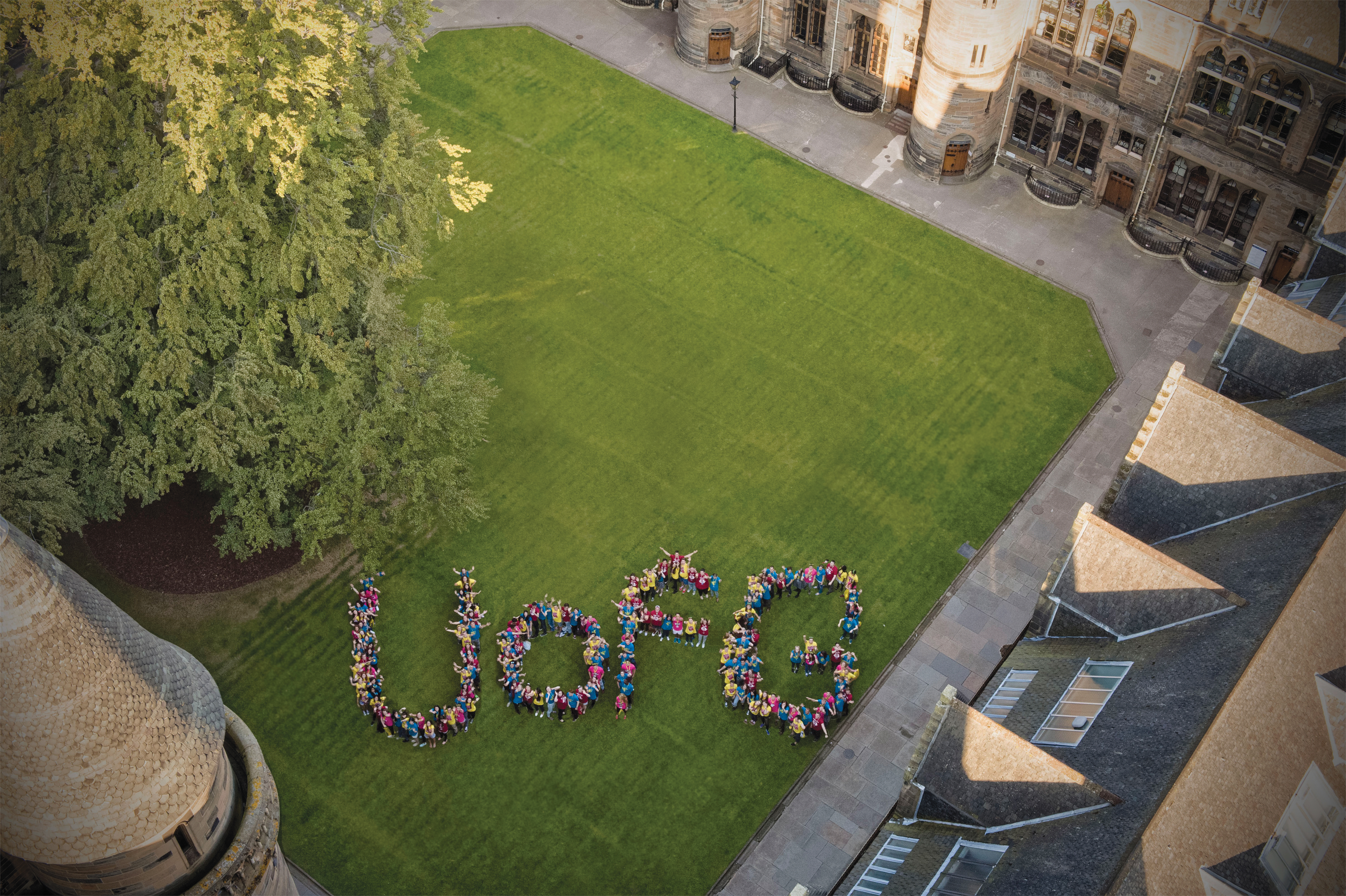 aerial photo of people forming letters reading UofG standing on grass
