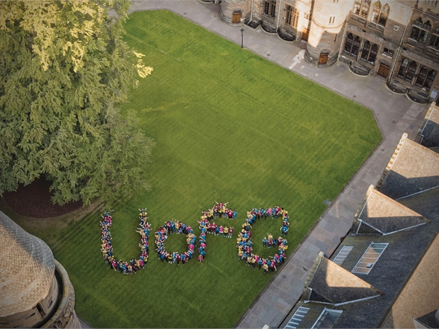 aerial photo of people forming letters reading UofG standing on grass